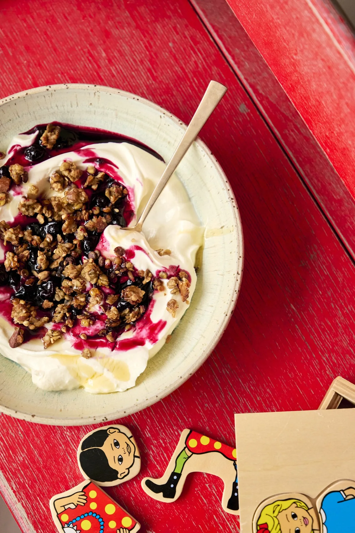 Banangranola med yoghurt og bær på et rødt bord